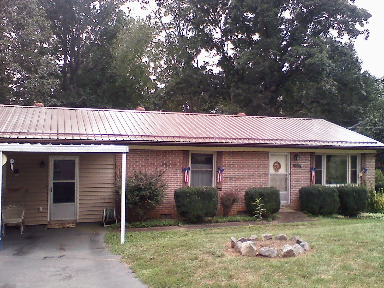 Bronze metal roof and carport on a brick ranch home — Roof Repair work by our crew in Millersport
